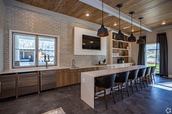 a kitchen with a long island with a breakfast bar and a large window with a view of